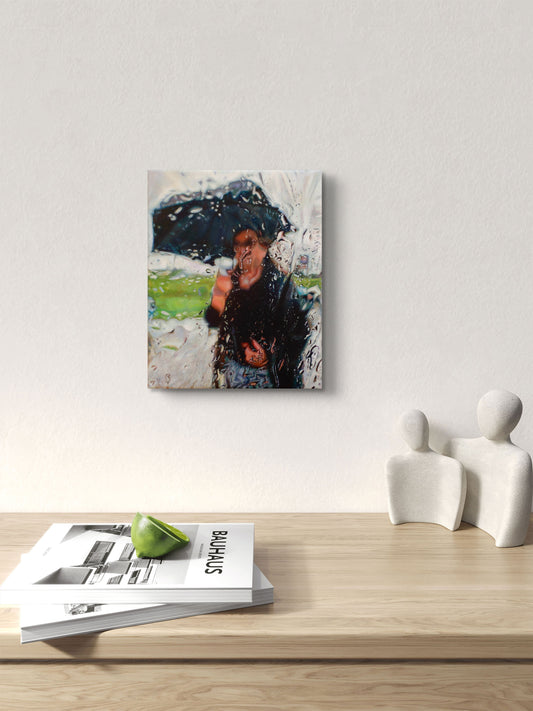 Original artwork of a person with an umbrella on a wall above a wooden surface with magazines and sculptures.